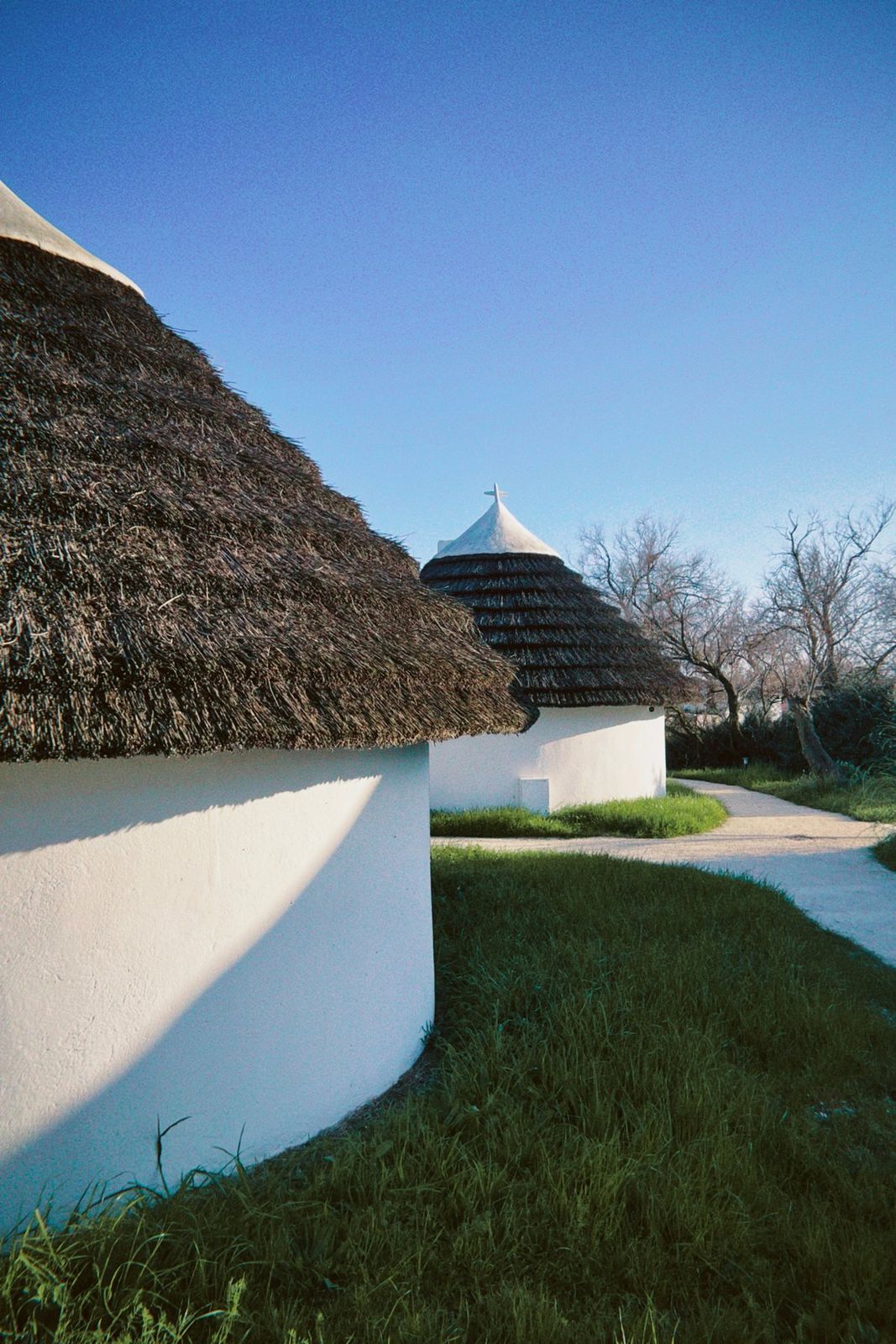 Cabanes blanches au toit de chaume sous un ciel bleu